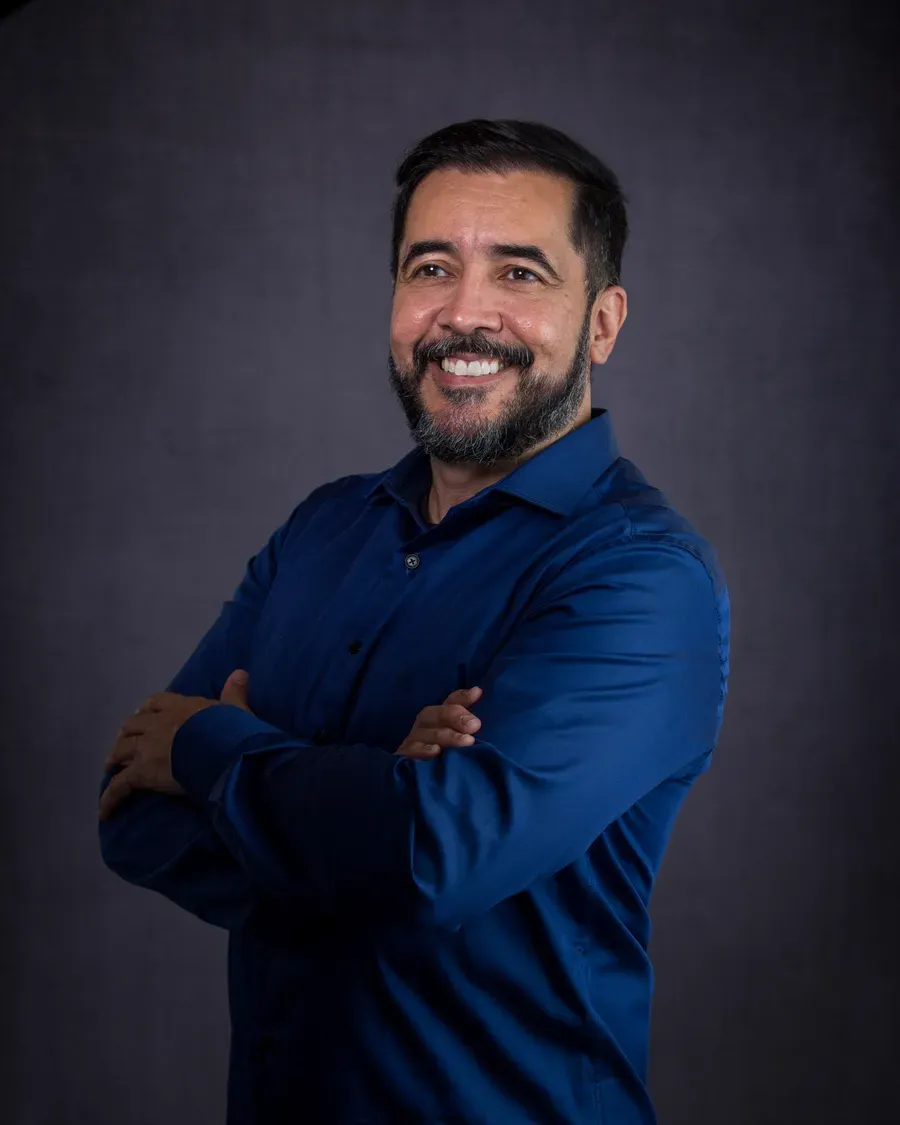 Dr. Kleber Meireles, ortodontista, em retrato de estúdio com braços cruzados